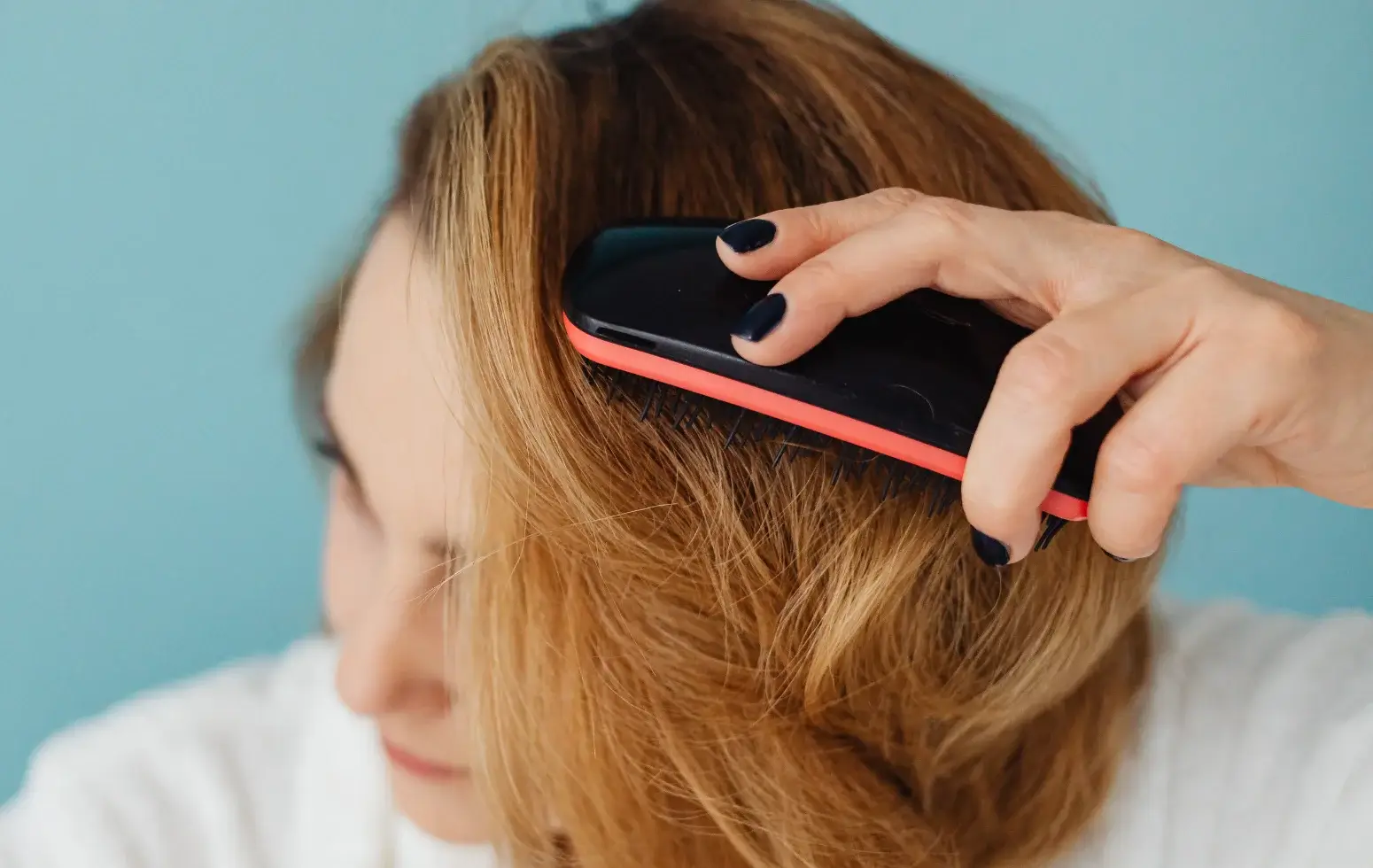 kobieta ma łupież i czesze blond włosy szczotką